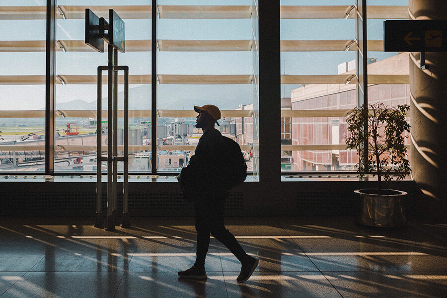 Man walking in airport with personal item backpack